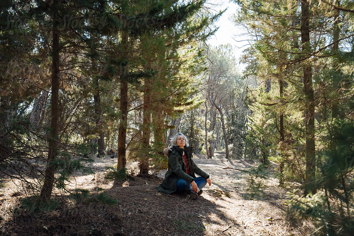 Mature woman enjoying fresh air in forest