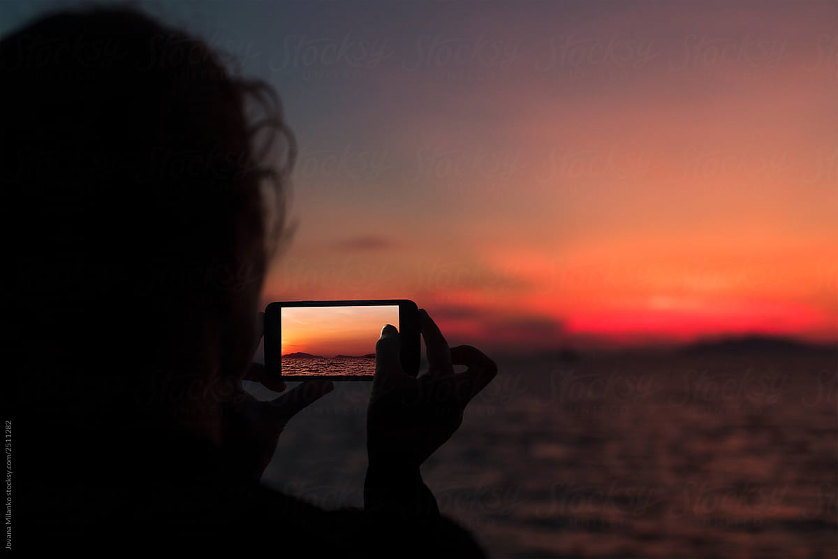 Tourist taking a photo of sunset