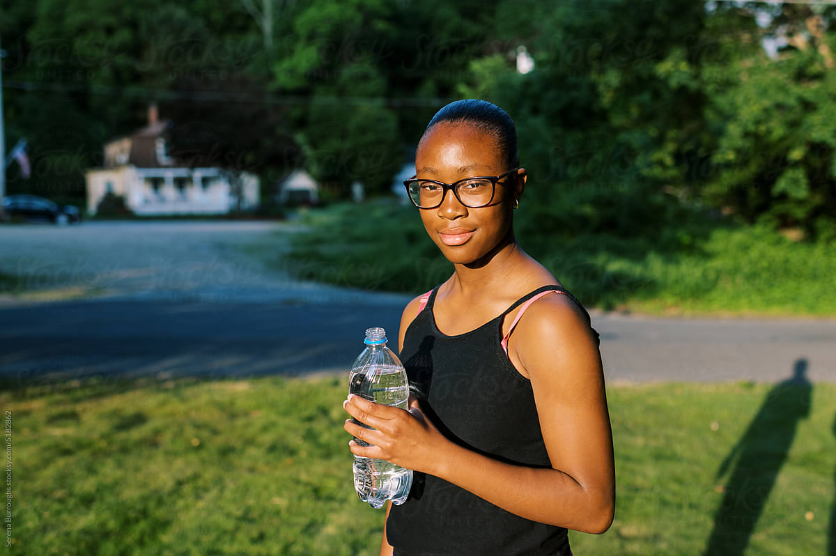 Smiling Pre-Teen Black Girl In Work Out Gear Holding Water Bottle
