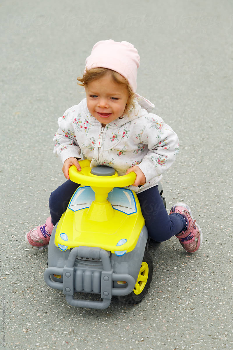 Glad toddler riding car on asphalt