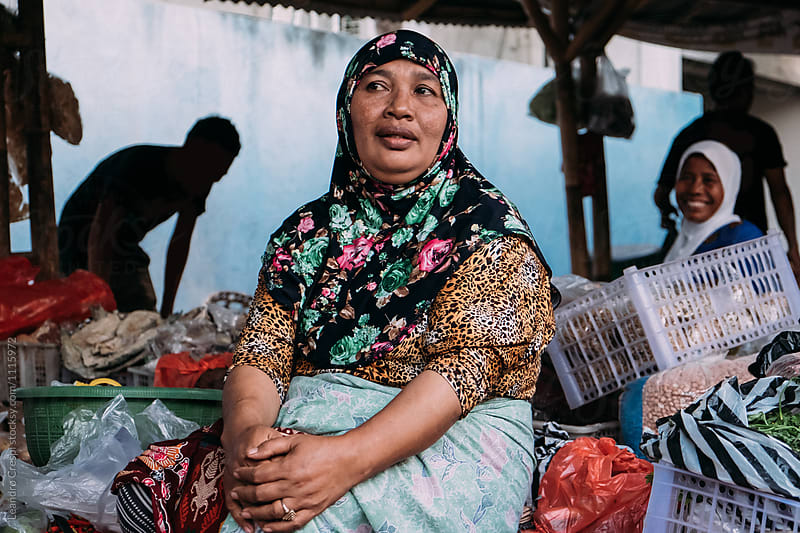 Indonesian old woman selling fruits and vegetables in local market