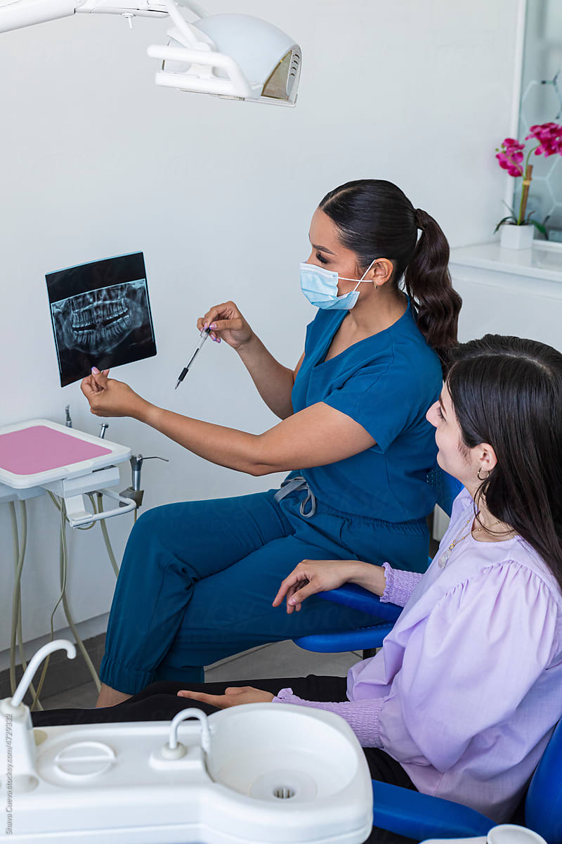 Dentist showing x-rays to a patient seated in a chair