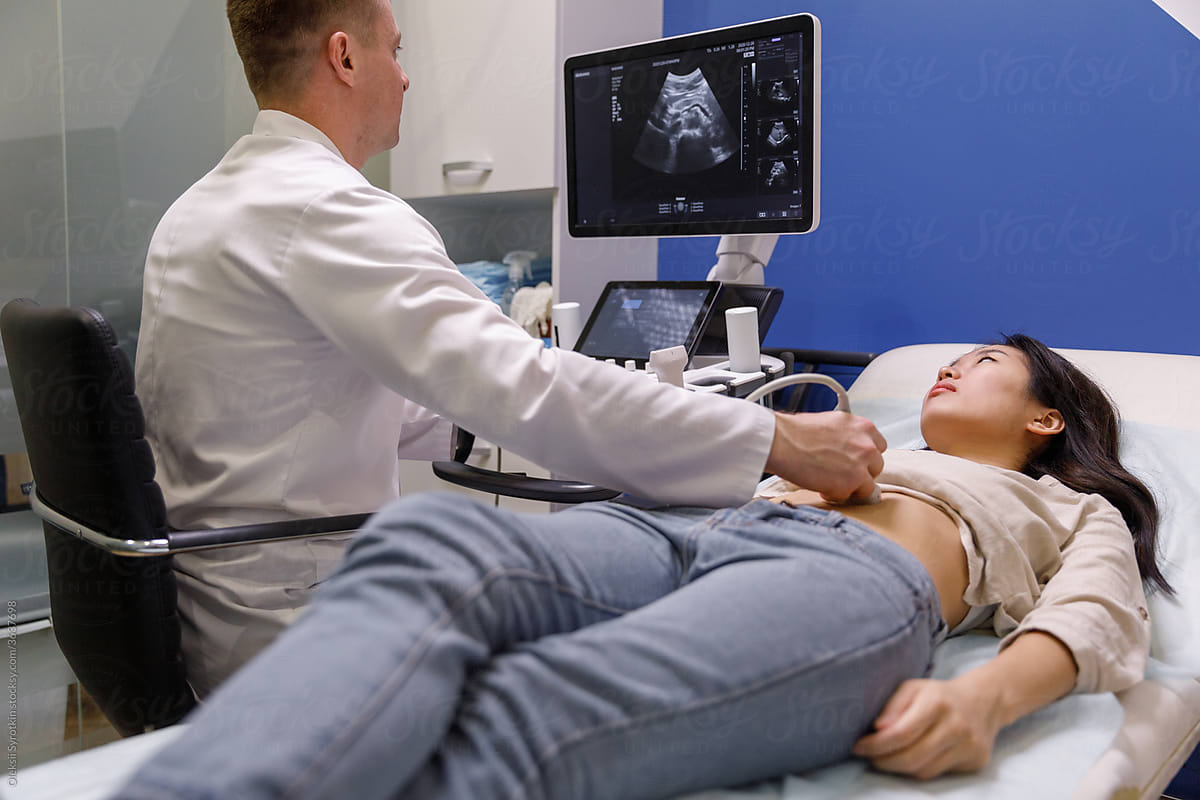 Physician considering sonogram scan on monitor