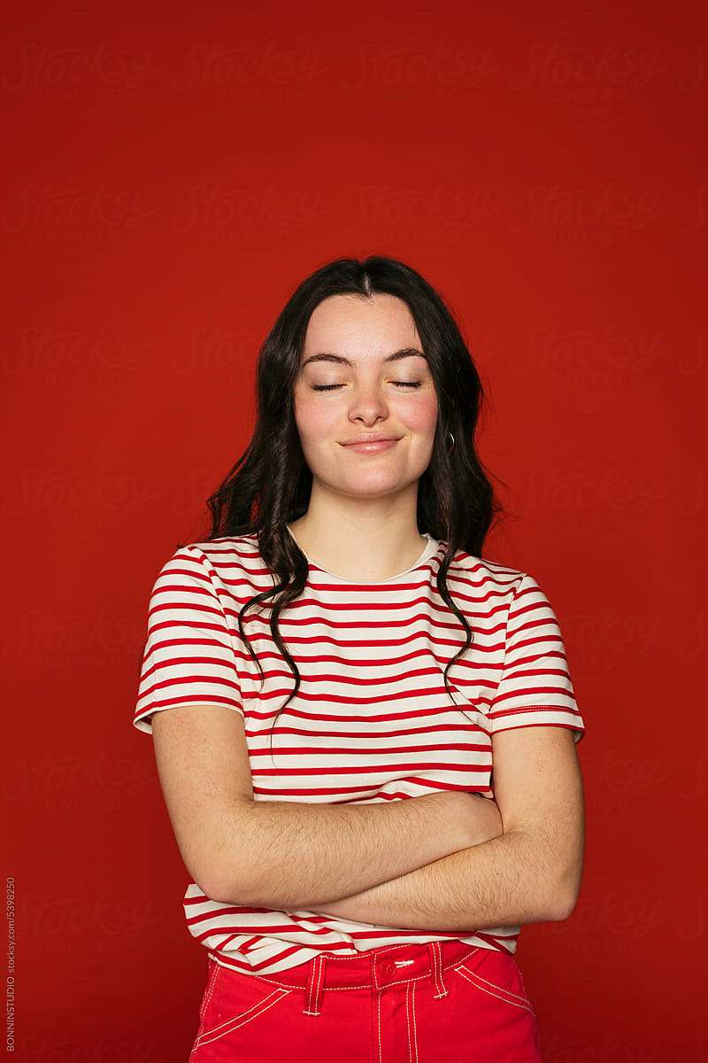 Cheerful woman posing on red wall