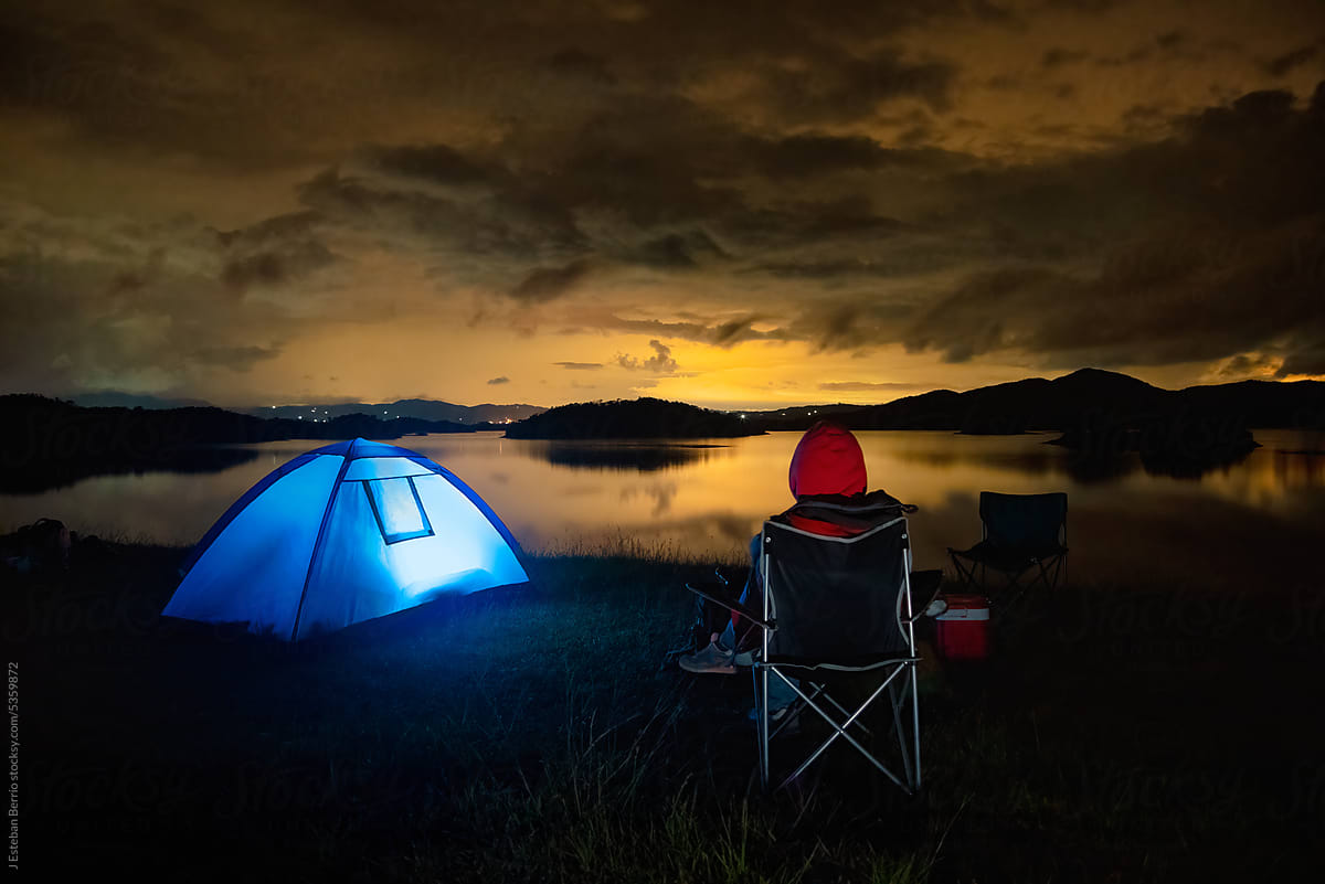 Person camping near a lake