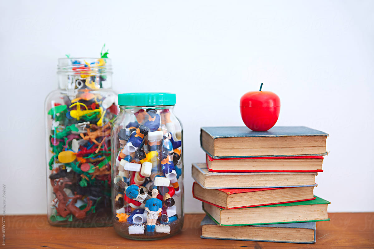 stack of books and toys in glass jars