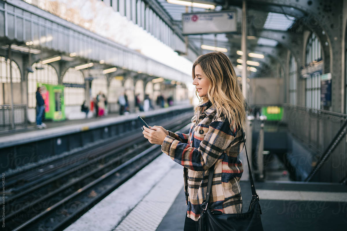 Female tourist using smartphone in metro station