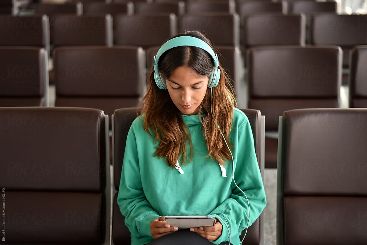 Young traveller using  digital tablet with headphones