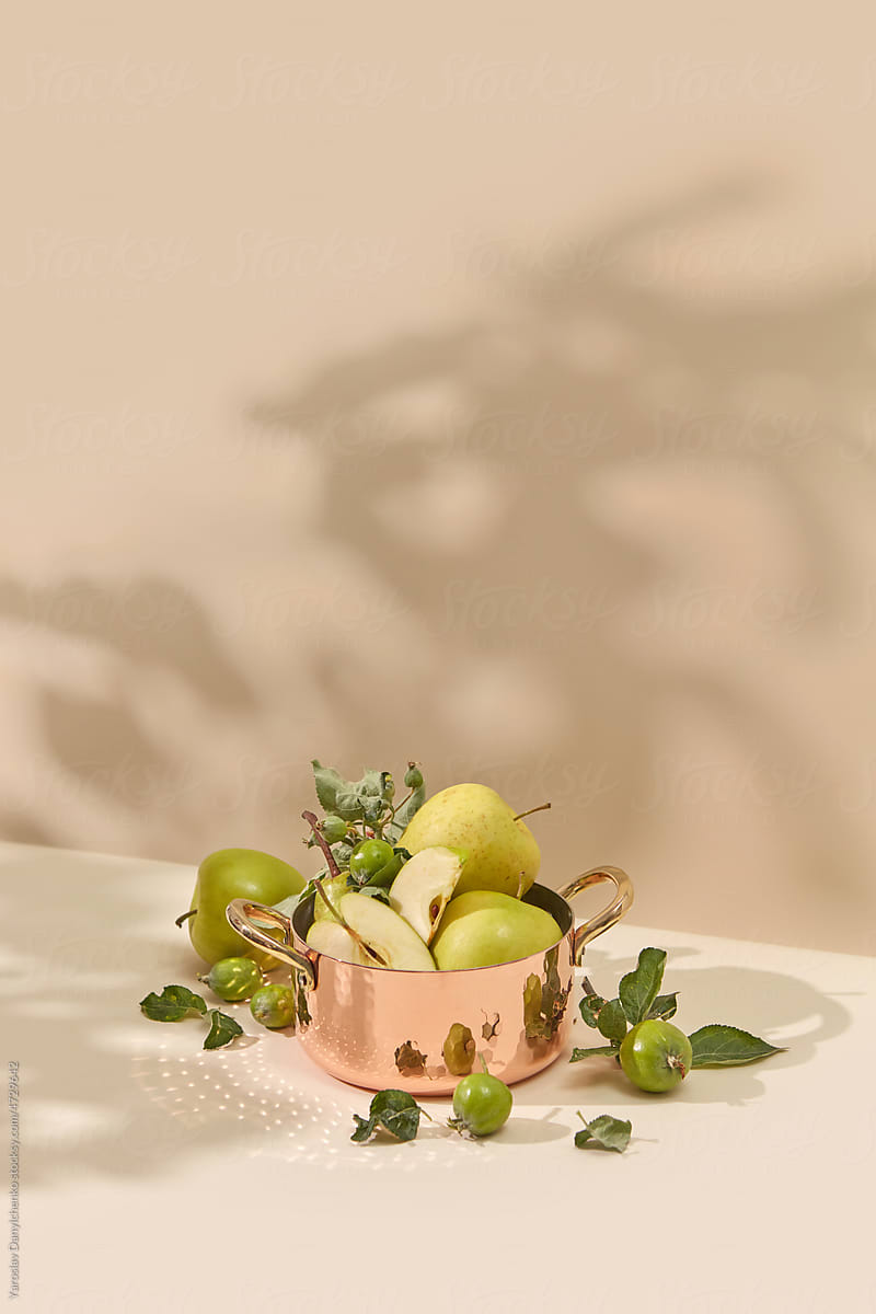 Vintage copper pan with fresh green fruit.