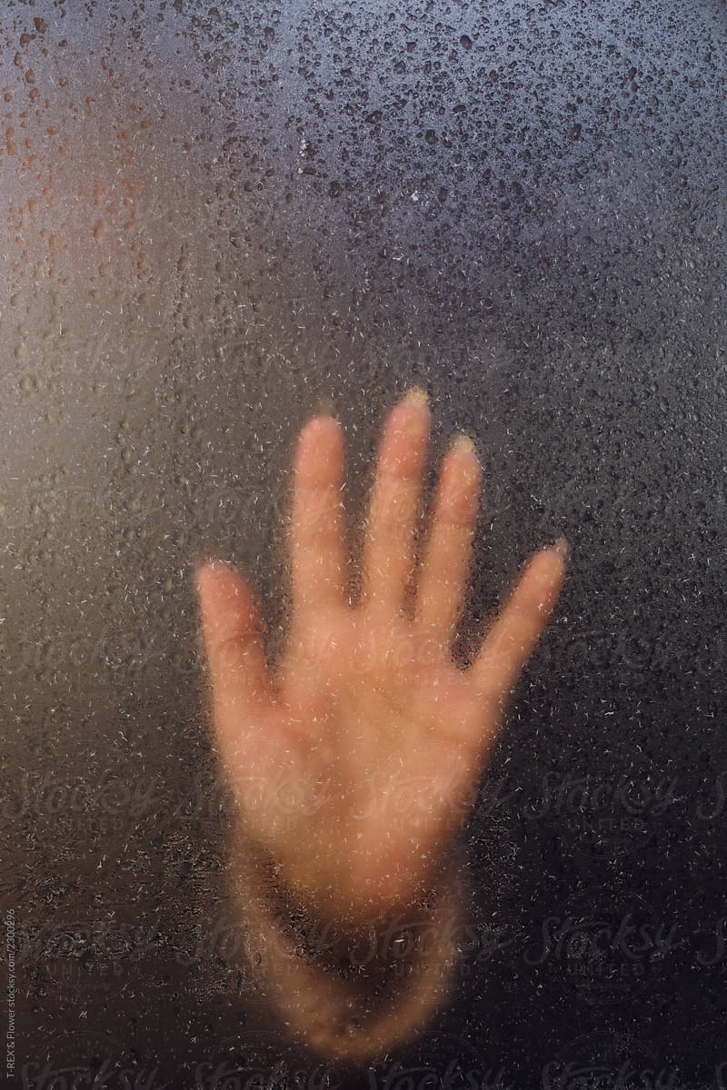 Crop hand touching wet glass