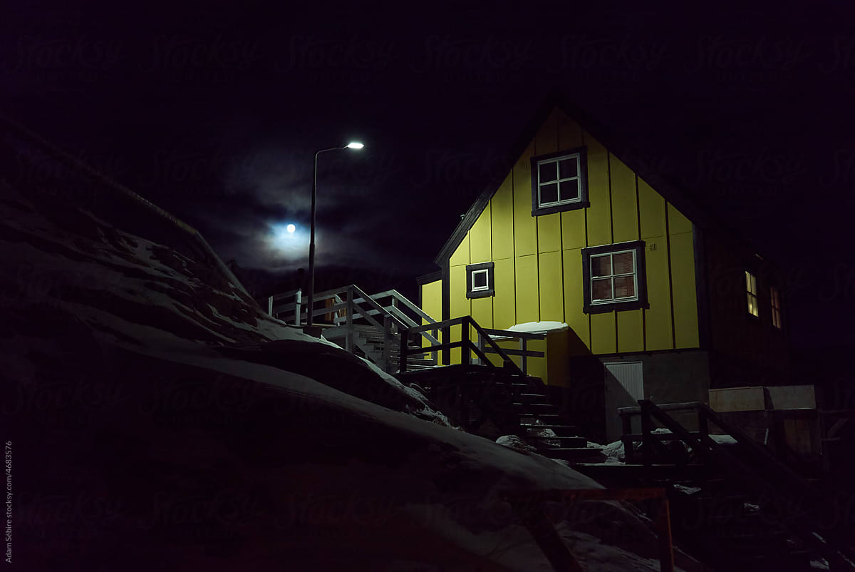 Greenland house winter polar night - village streetlight, dark clouds
