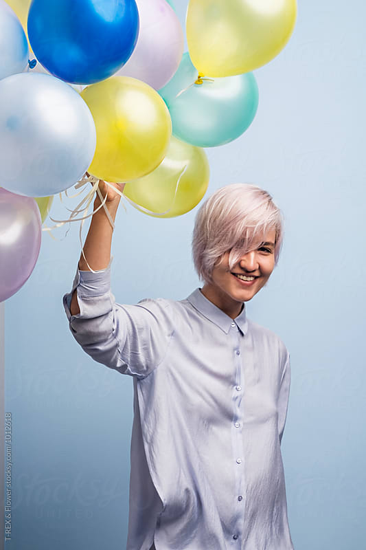 Cheerful young girl with bunch of balloons