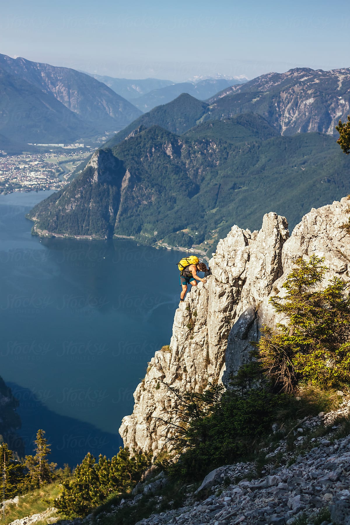 sporty male climber climbing up a wall in austrian seascape scenery
