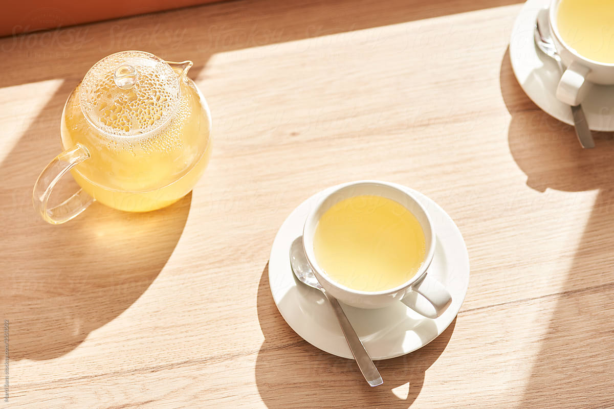 Cup and teapot of natural drink on table