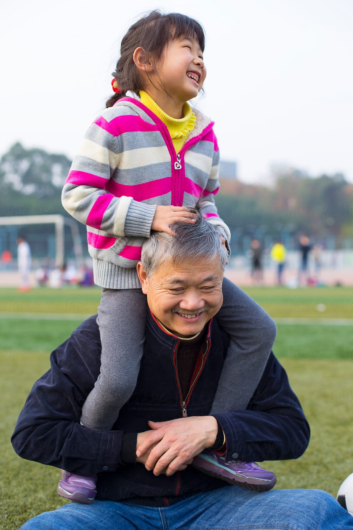 One Little Girl Sitting on her Grandfather\'s Shoulder