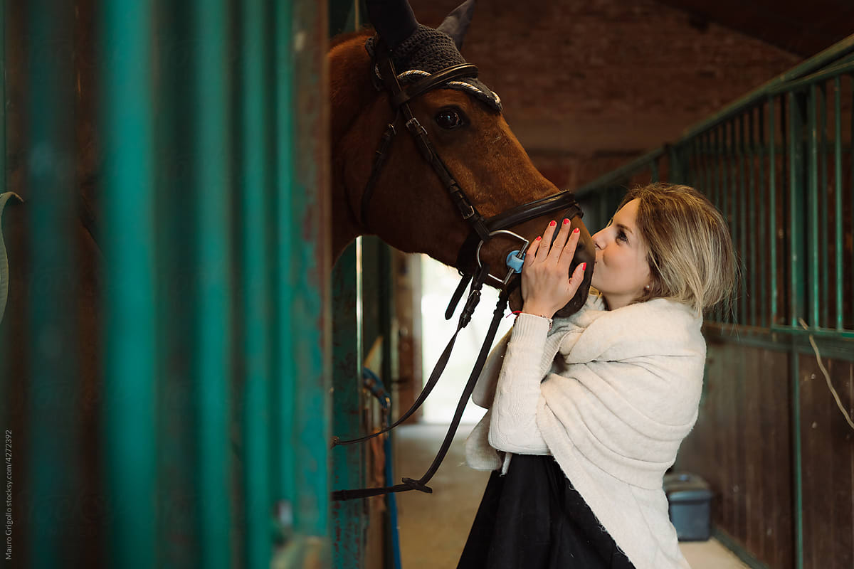 Woman kissing the muzzle of her horse