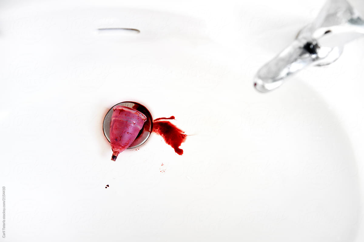 Menstrual cup emptied into a sink drain
