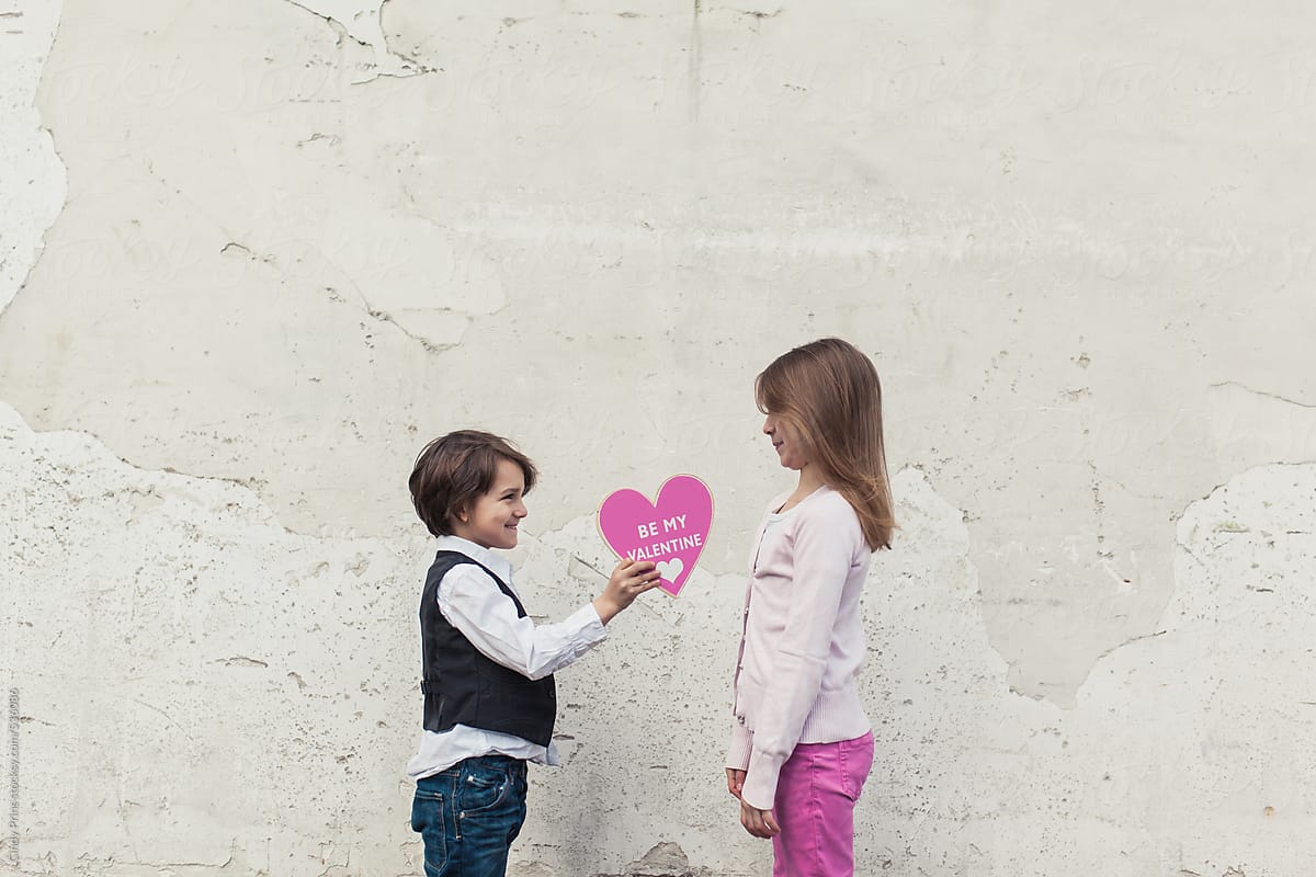 Little Boy Giving A Girl A Big Pink Valentines Day Heart/ photo