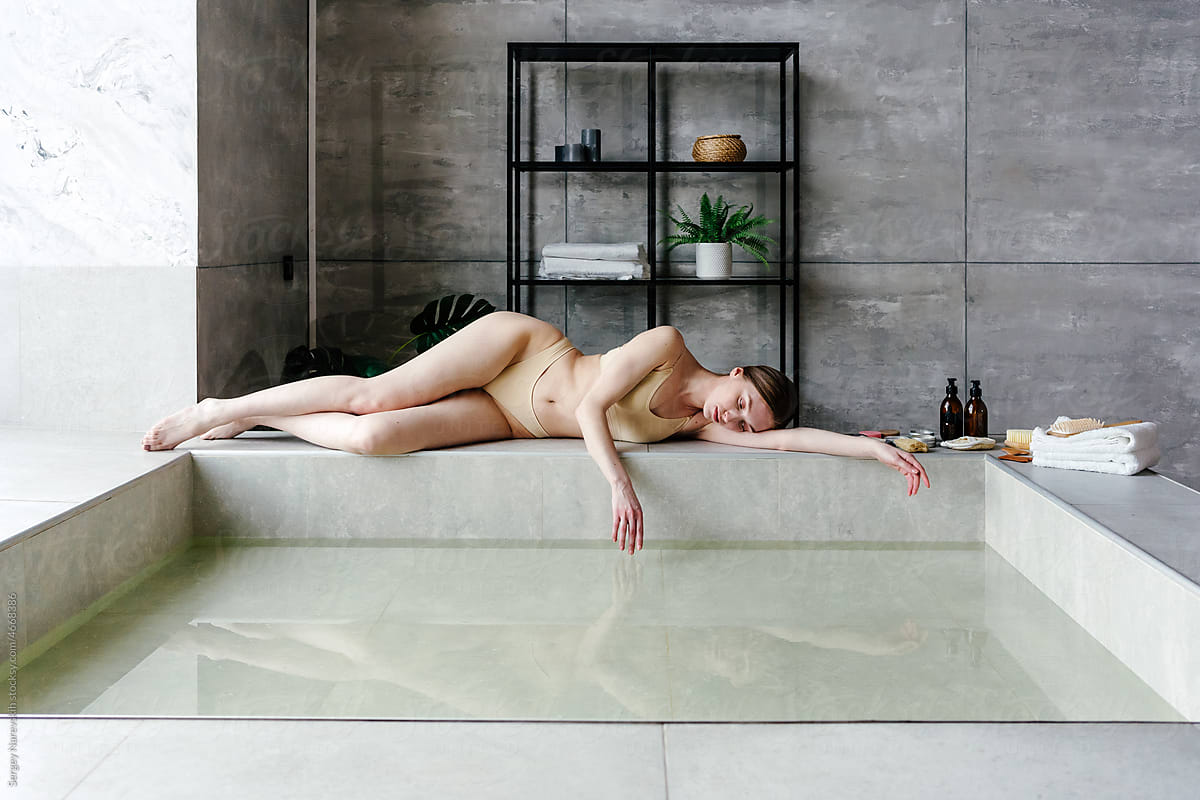 Woman on bathtub border in spa center