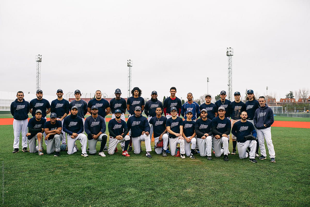 Multiracial baseball team posing on field
