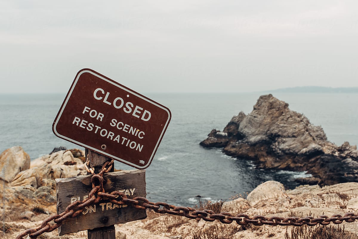 Closed for scenic Restoration sign by a rocky cove
