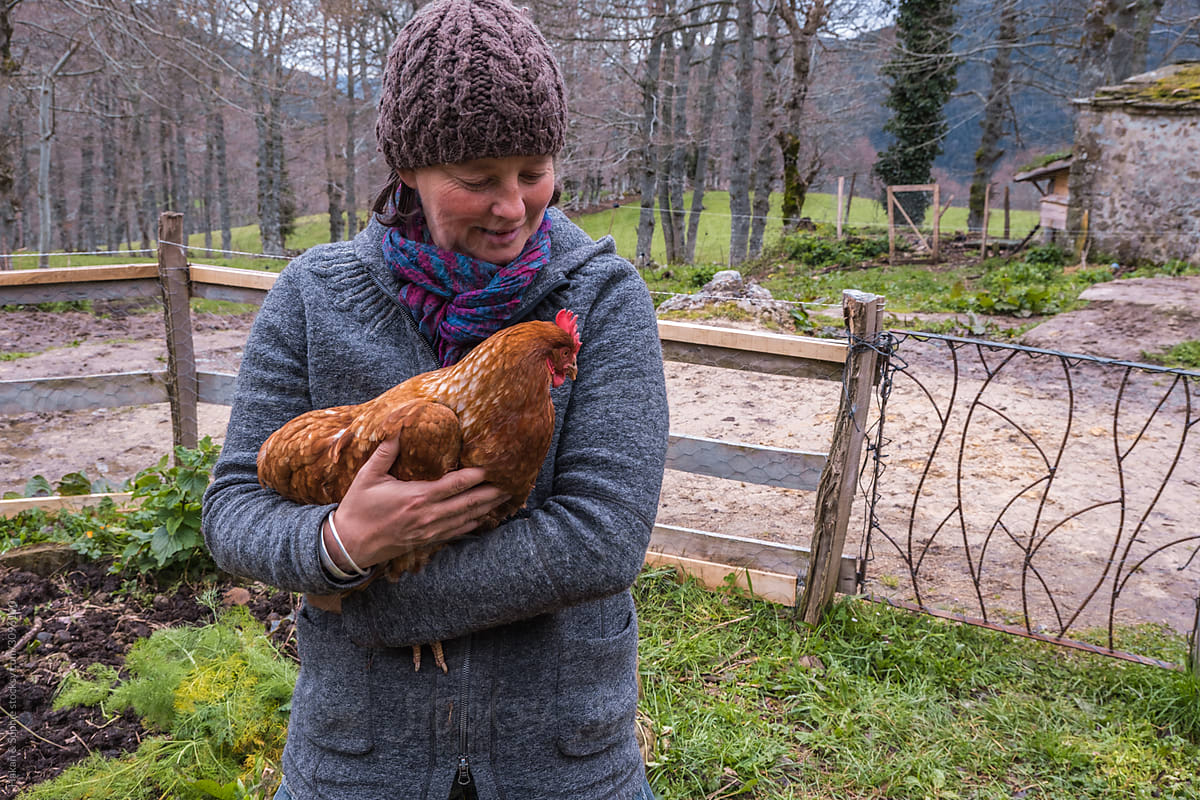 woman holds a chicken in her arms