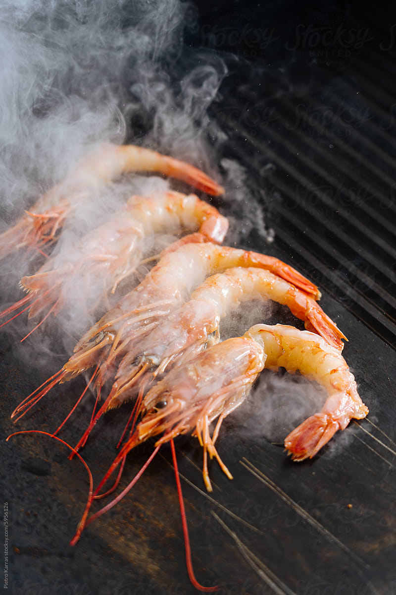 Shrimp Being Cooked on a Grill With Smoke