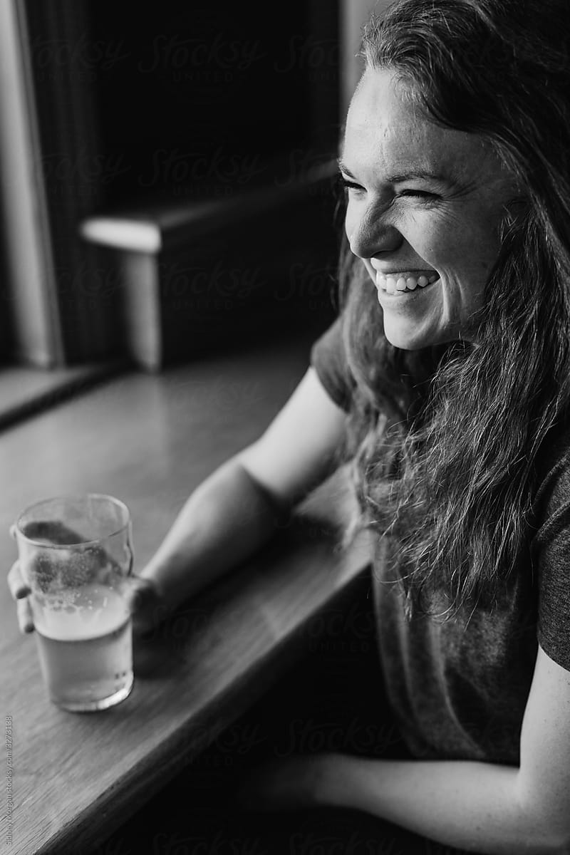 Young Woman Drinking a Beer at a Bar