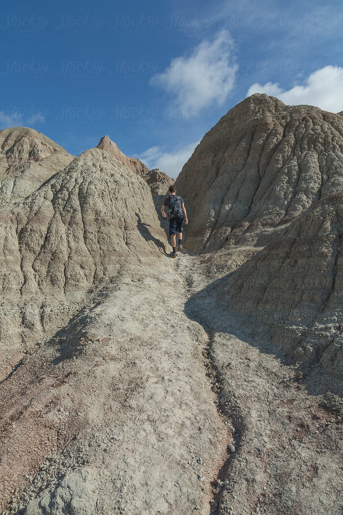 Hiker climbing up a sand stone hill