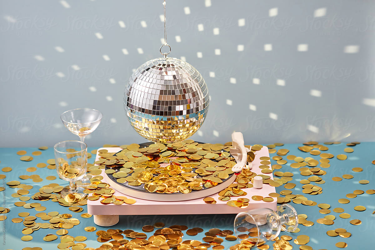 Vinyl player with disco ball and golden confetti.