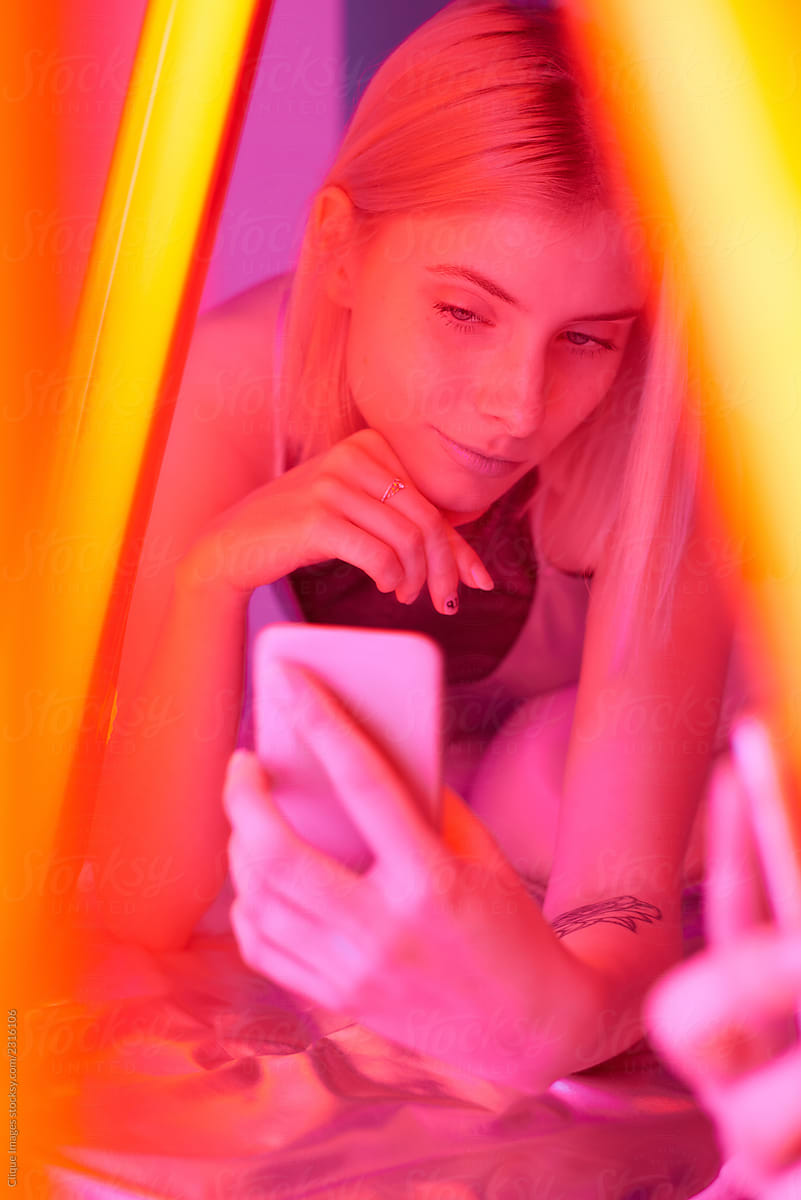 Young Female Model taking selfie in yellow neon