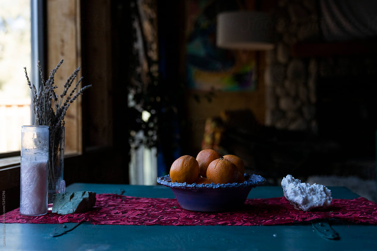 A bowl of oranges on a turquoise table