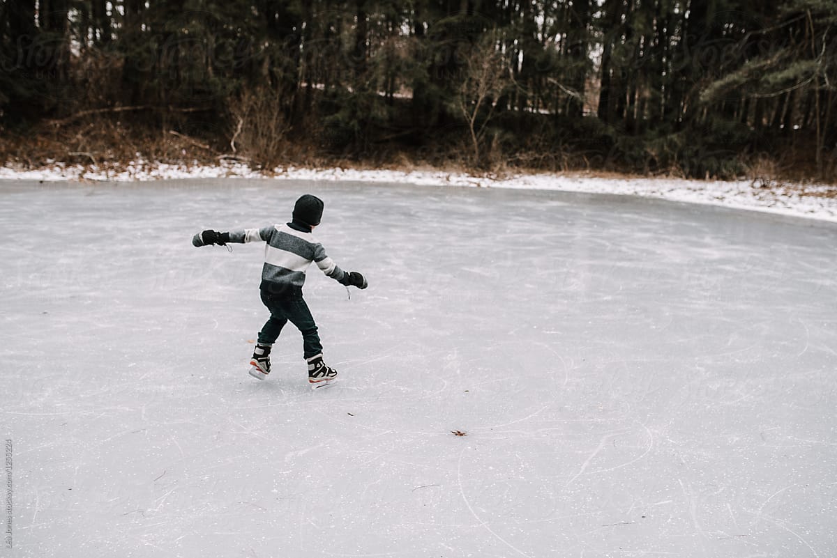 little boy skating on frozen pond