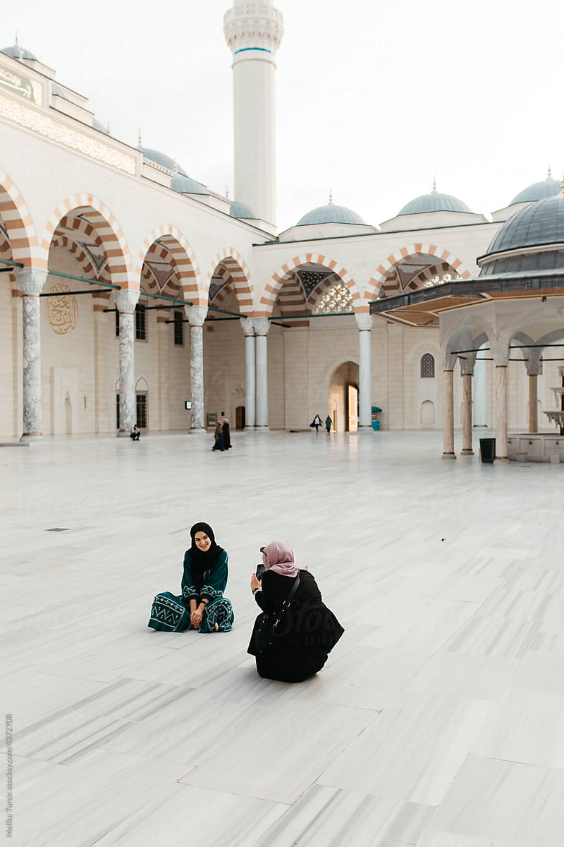 hijabi woman sitting in a mosque yard.