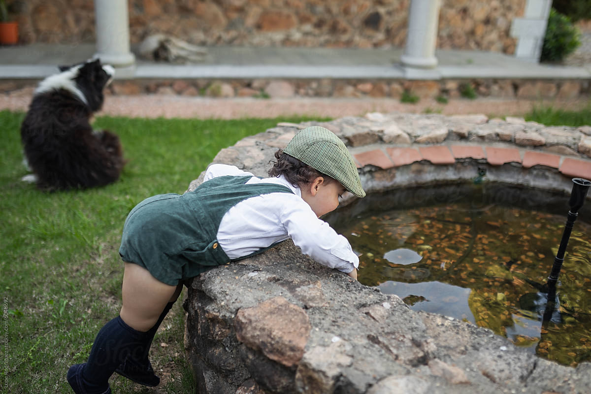 Adorable child next to a fountain in a country house in spring