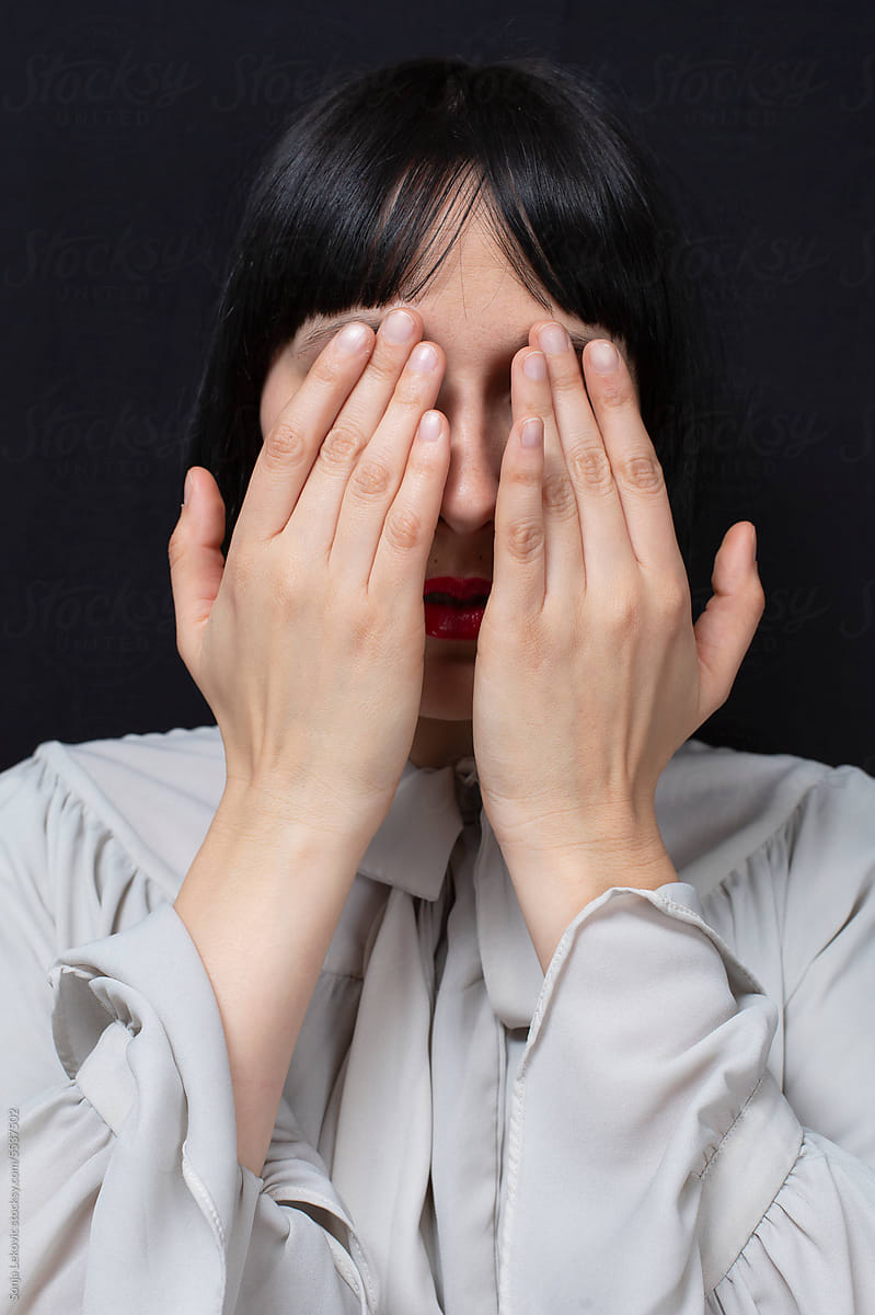 woman covering her face with hands