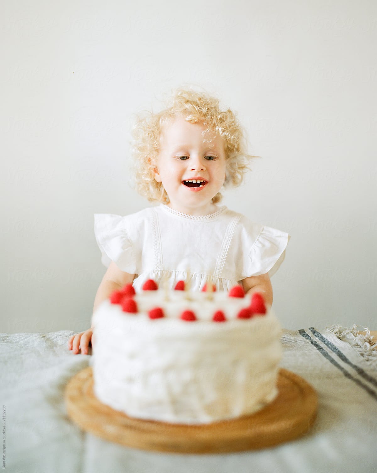 A kid looking at her birthday cake