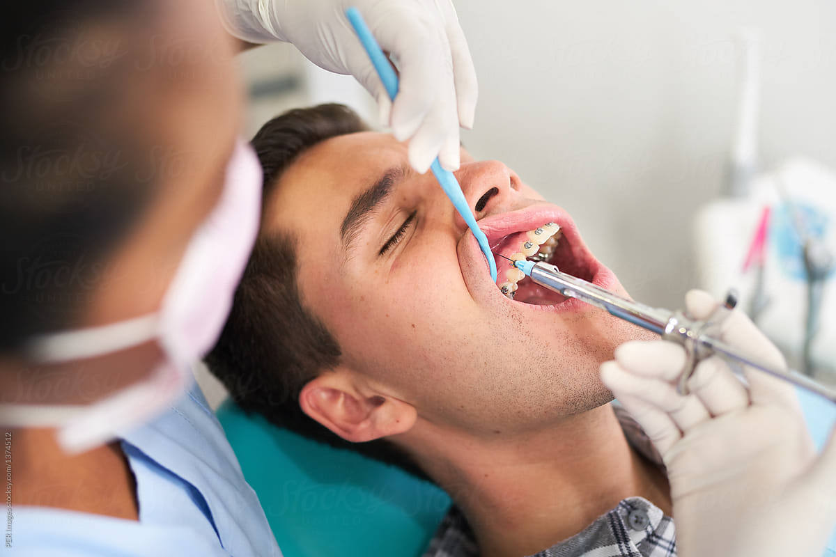 Dental patient receiving an injection of anesthesia from his dentist