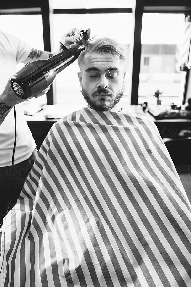 black and white of barber blowing client\'s hair