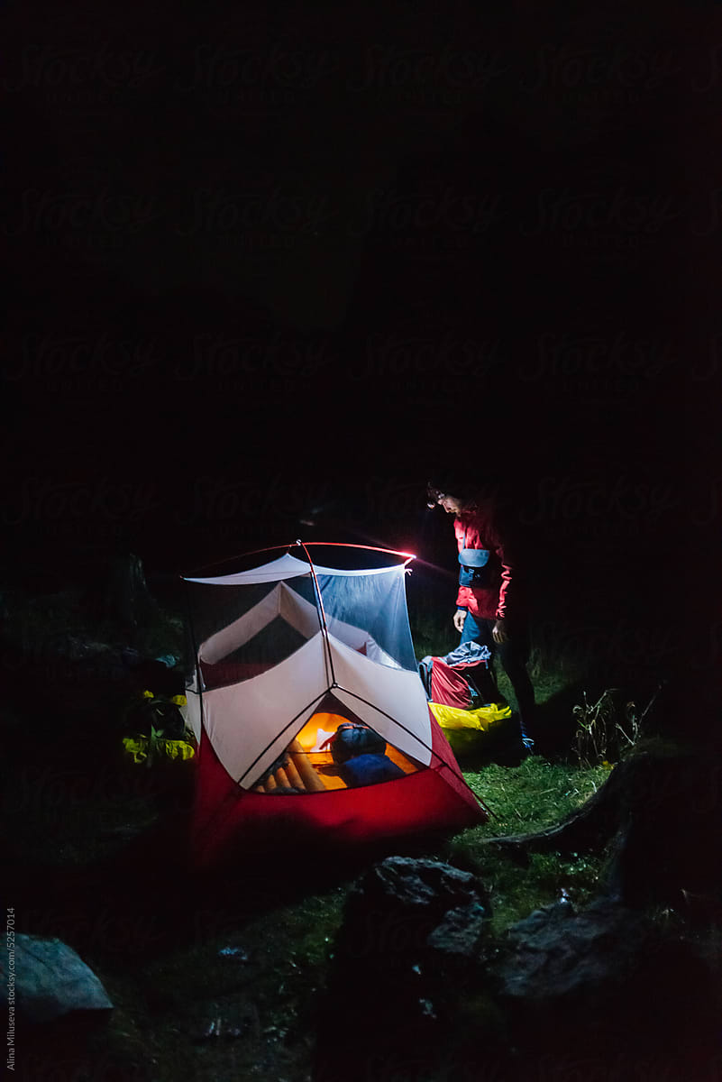 Hiker Setting Up Tent At Night