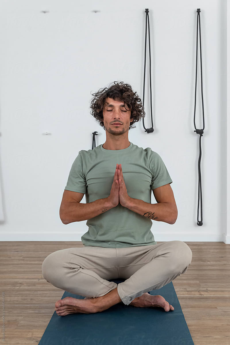 Man meditating in Lotus pose in studio