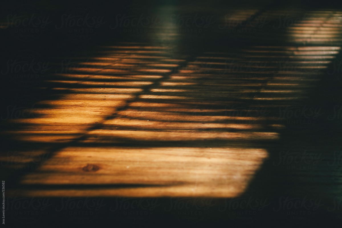 shadow of window blinds on a wood floor