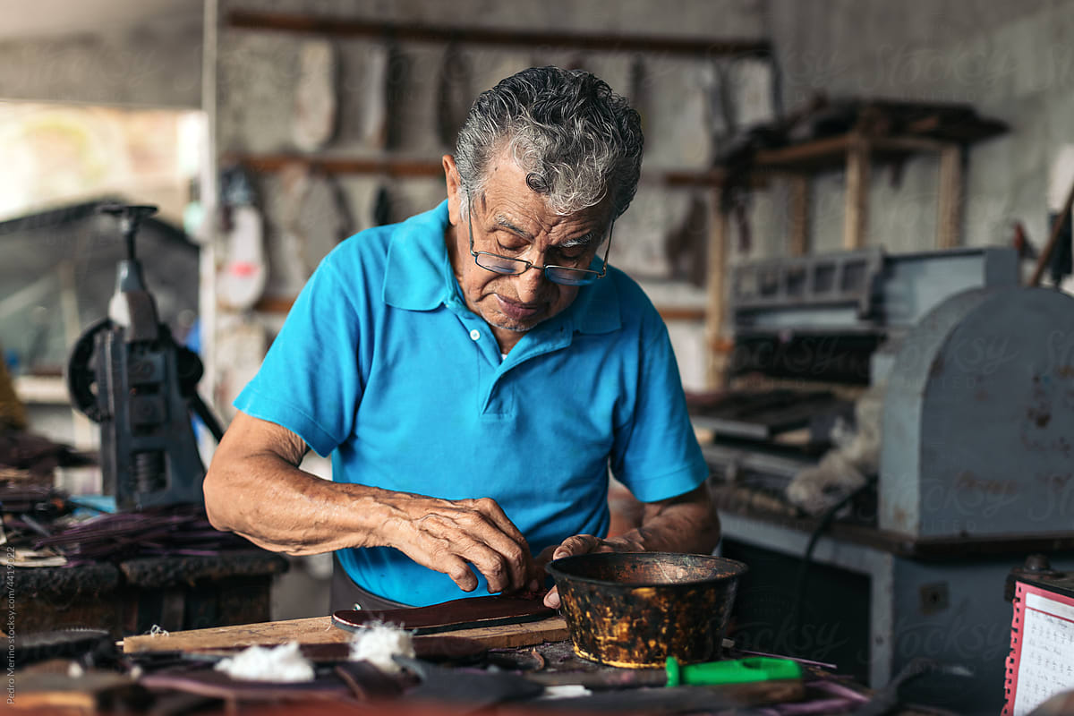 Senior shoemaker dyeing some soles