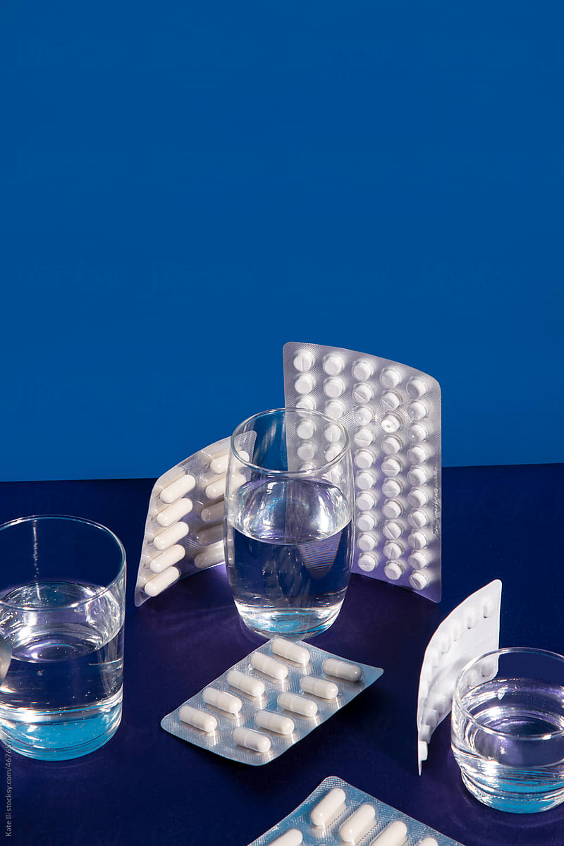 Glasses with water surrounded with pills