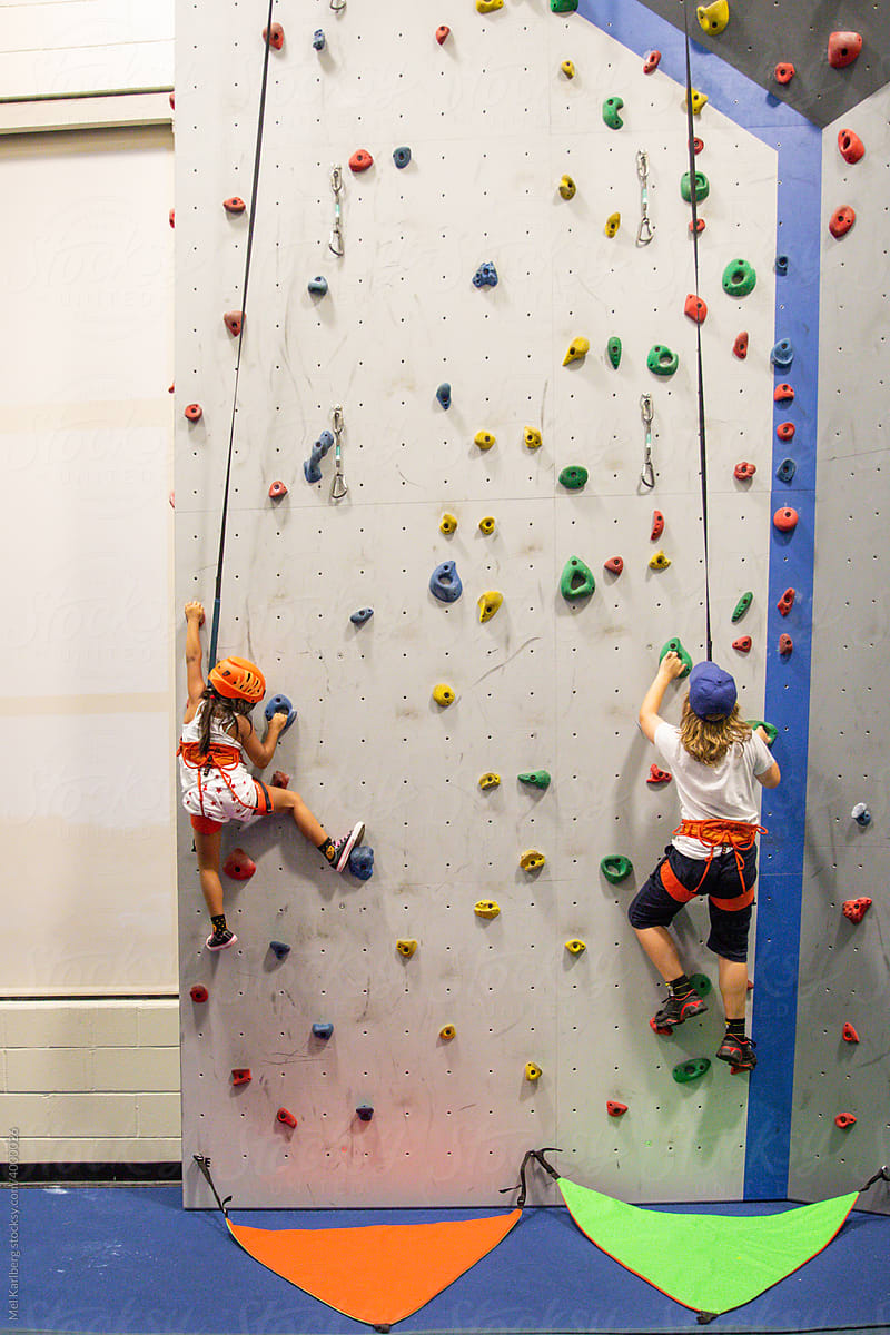 Boy and girl climbing on an indoor rock wall