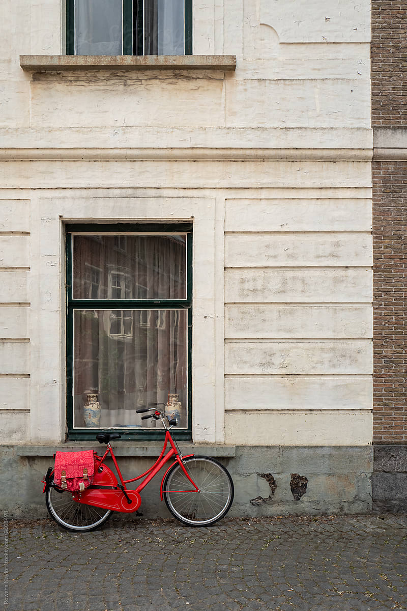 Red bike against wall in Bruges city