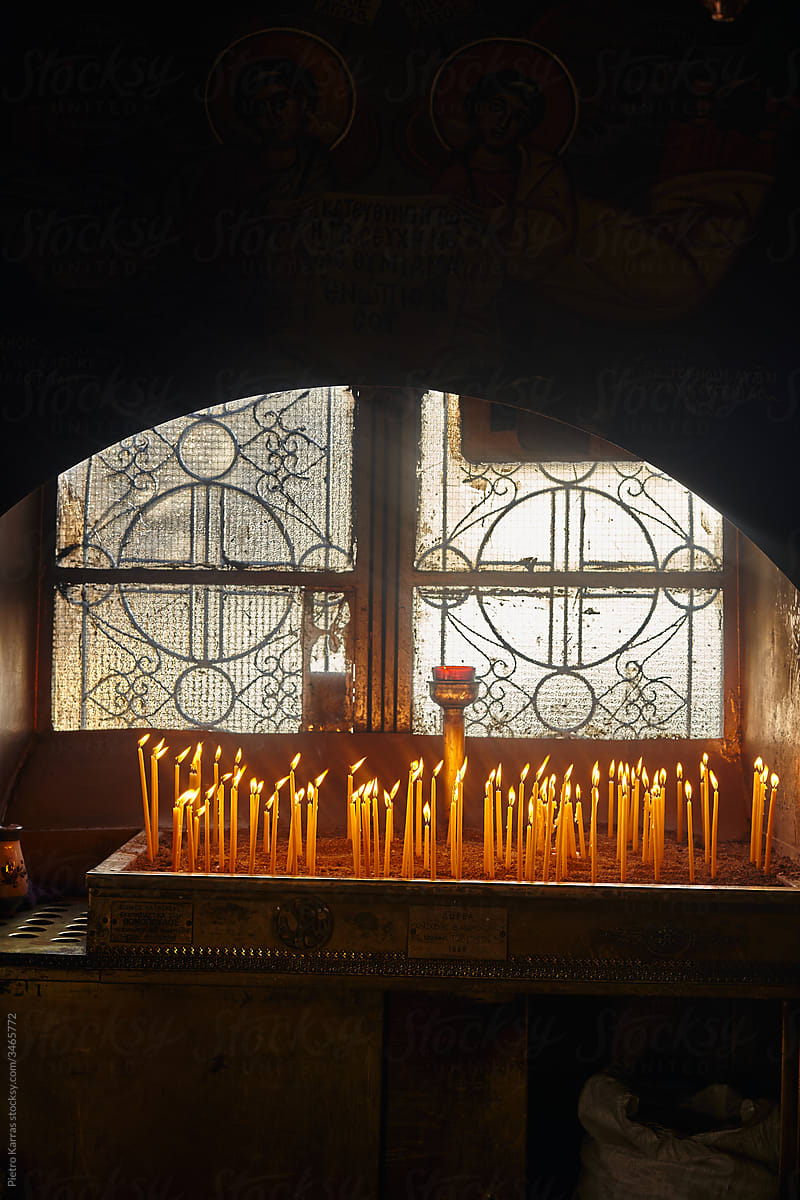 Candles burning near window in church