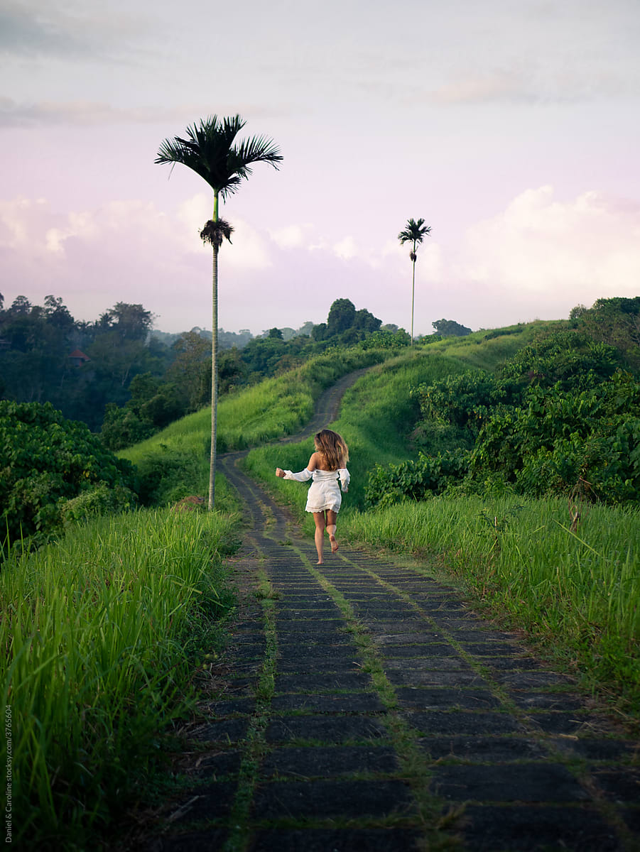 Woman running on tropical nature walk with palmtrees