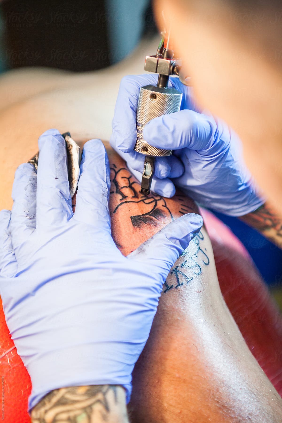 A tattoo artist using a shading gun.