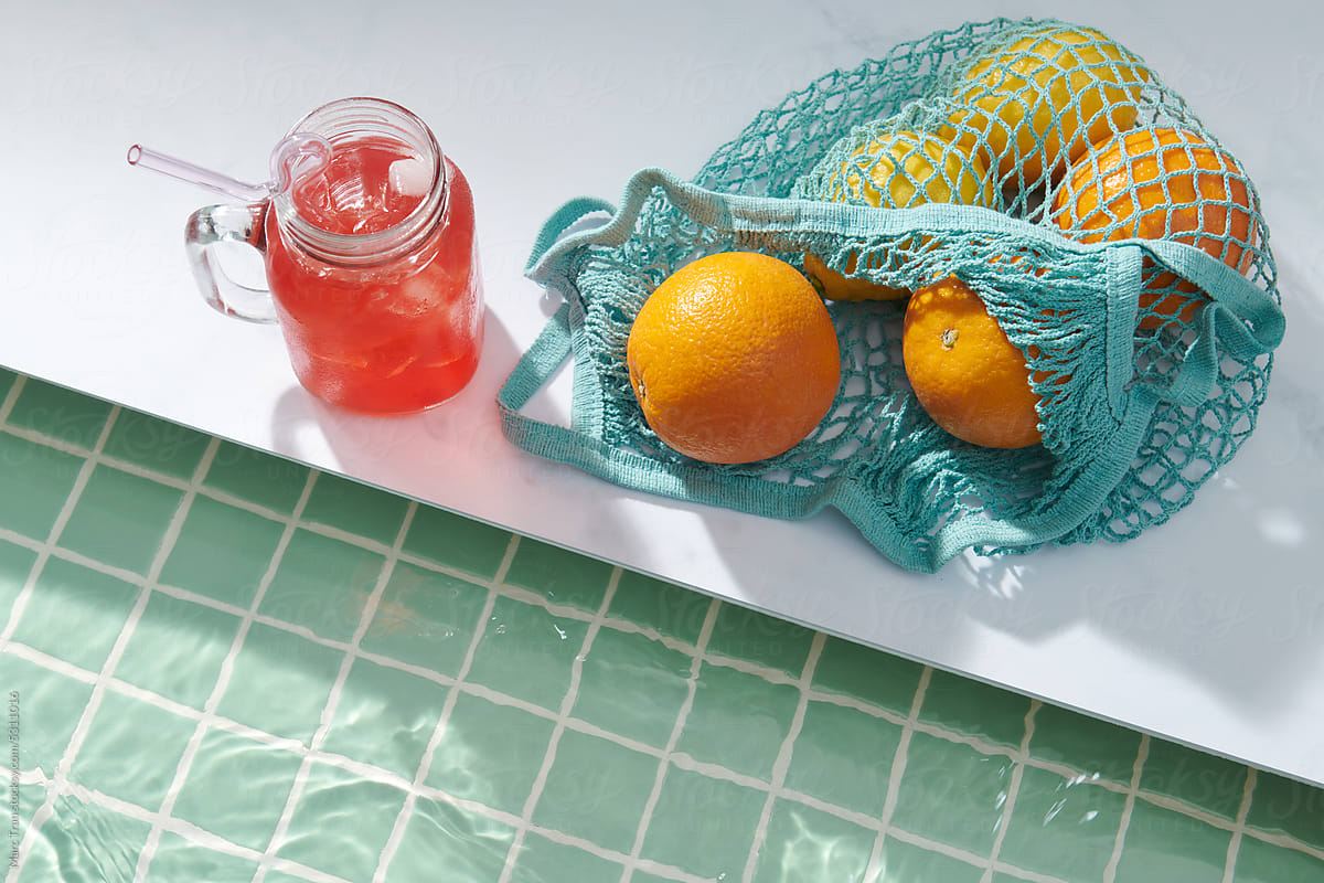 Ripe orange and lemon in a String Bag and glass of watermelon juice